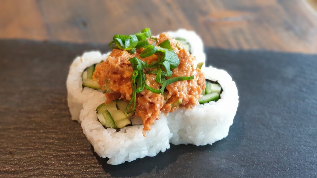 4 Spicy No Tuna Rolls Sushi auf einer schwarzen Schieferplatte